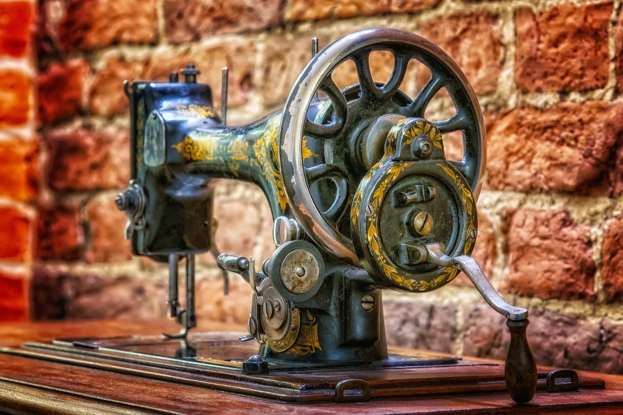 Immagine di una vecchia macchina da cucire vintage su un tavolo, simbolo di artigianato e valore collezionistico.